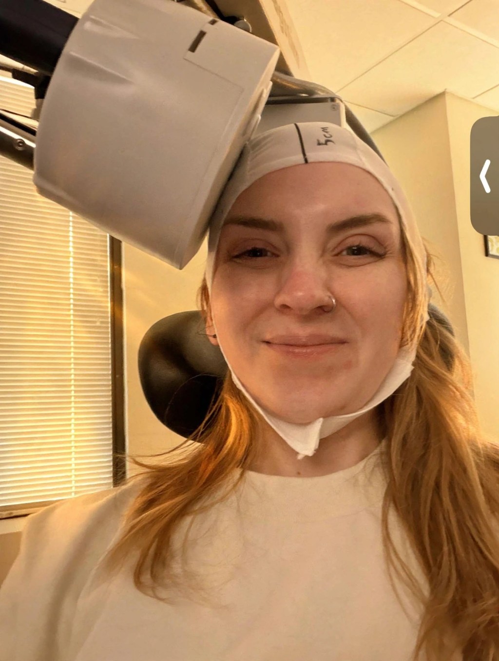 Warm-toned selfie of Tara during her TMS treatment session